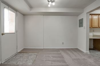 A room with a carpeted floor and a door on the left side